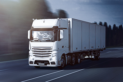 Ein weißer LKW Transporter der auf einer Straße fährt